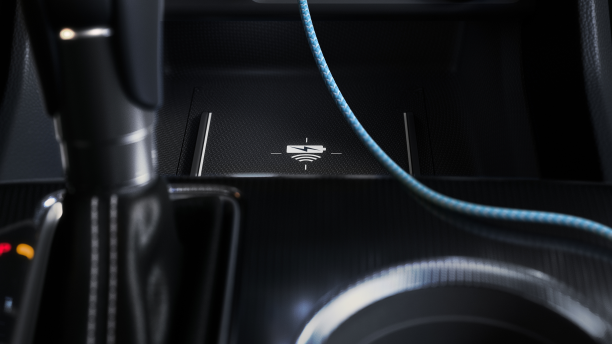 Closeup of wireless charging pad in front of gear shifter.