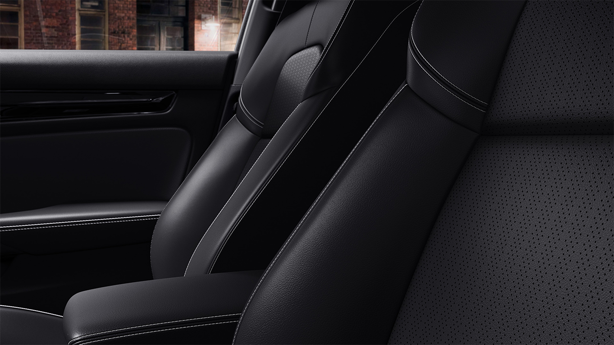 Closeup of black seat with white stitching.