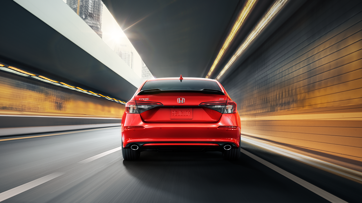 Vue arrière d’une Civic Si rouge roulant dans un tunnel.