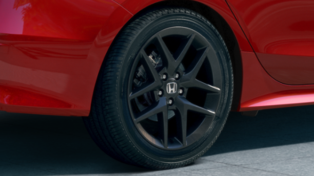 Gros plan de la roue noire d’une Civic Si rouge.