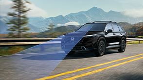 3/4 front view of black CR-V driving on forest highway with mountains in background. Blue sensor lines emit from the front. 