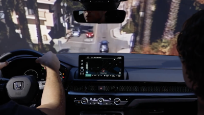 Interior view of woman driving CR-V diving downhill in the city.