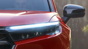 Closeup of front headlight on a red CR-V.