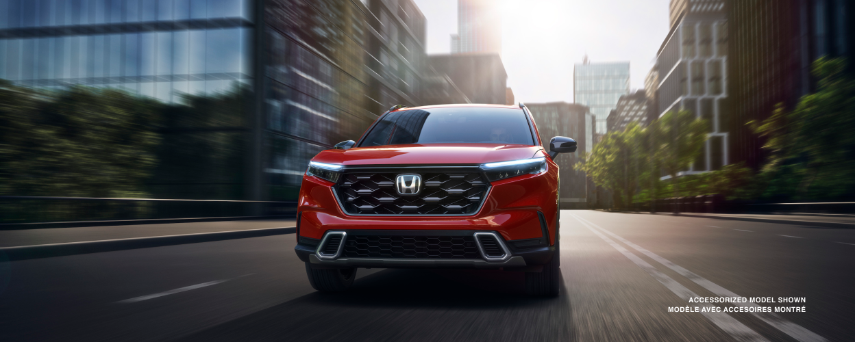 Front view of red CR-V driving in the city; toward camera.