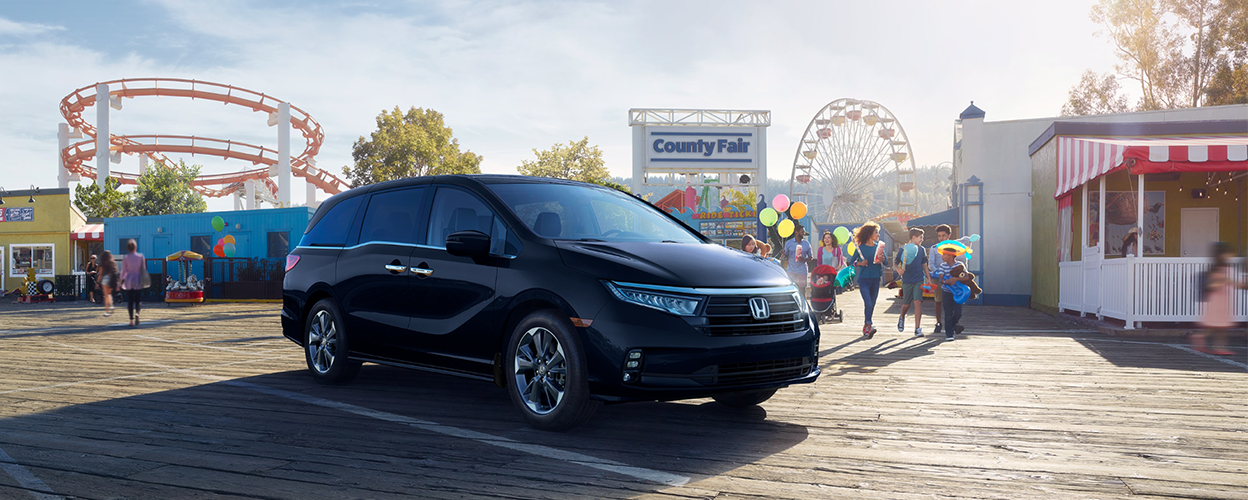 3/4 front view of black Odyssey parked outside a county fair.