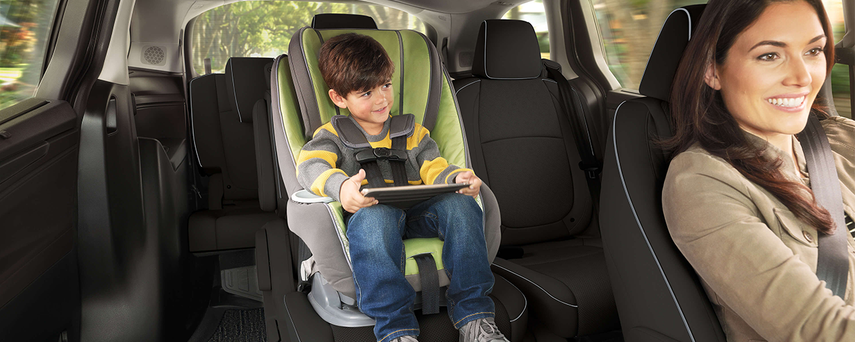 Interior view of Odyssey. Mom driving; kid in car seat.