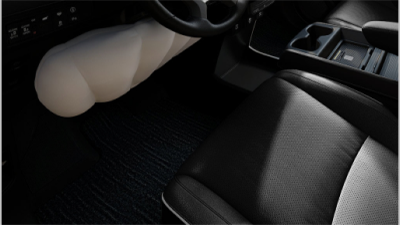 Closeup of inflated airbag under steering wheel.