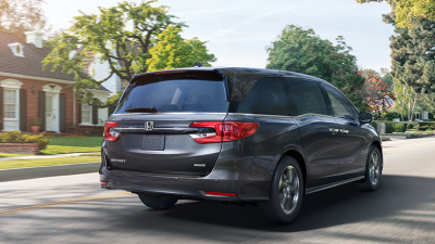 3/4 rear view of grey Odyssey braking in suburban street.
