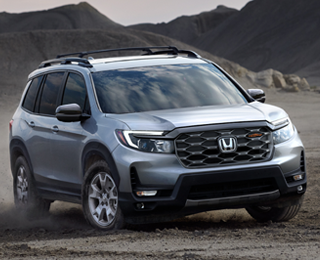 3/4 front view of grey Passport off-roading in desert.