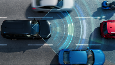 Plan en plongée d’un Pilot noir dans la circulation sur une autoroute. Des lignes et des ondes de capteur bleues détectent les véhicules à l’avant et sur les côtés. 
