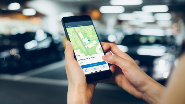 La main d’une femme parcourt l’application HondaLink sur un téléphone intelligent.