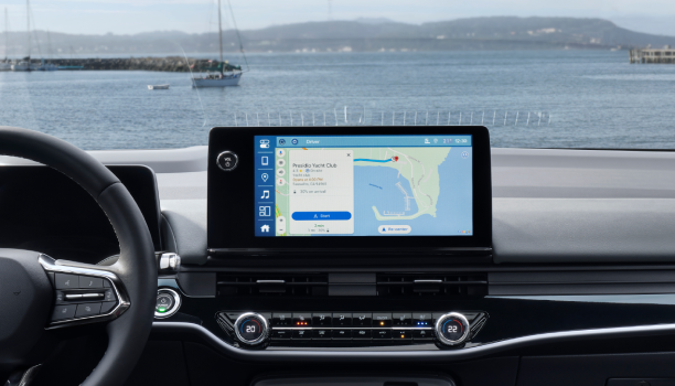 Interior closeup of steering wheel and Google Maps open on the touchscreen display.