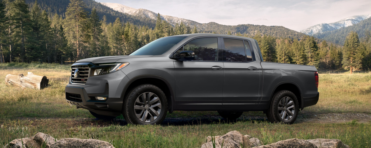 Side view of grey Ridgeline in forest.