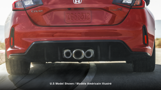 Straight on closeup of the triple centre exhaust on a red Type R racing on track.