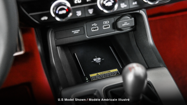 Closeup of wireless charging pad in centre console above gear shifter. 