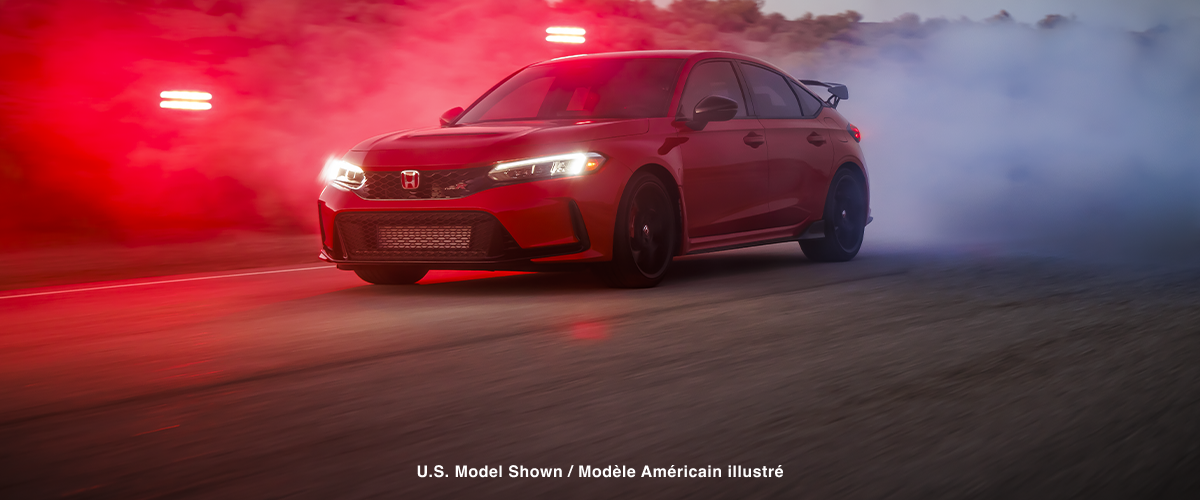 3/4 front view of a red Type R burning rubber on a desert road at dusk. 