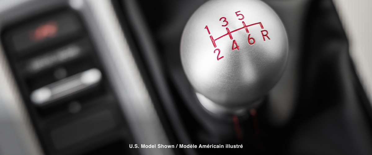 Extreme closeup of top of shifter, displaying the engraved gear map.