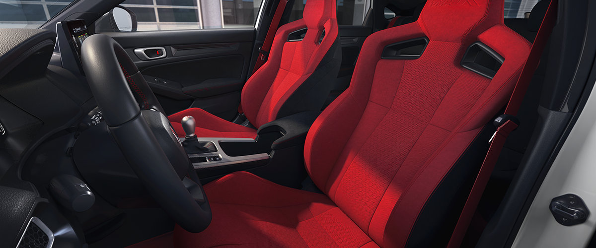 Wide shot of the two front red bucket sports seats.